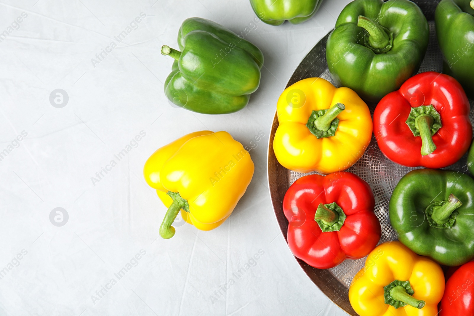 Photo of Dish with ripe paprika peppers on light background, top view