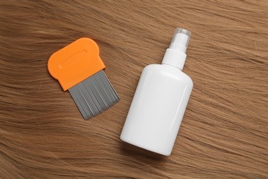 Photo of Comb and spray for anti lice treatment on blond hair, flat lay