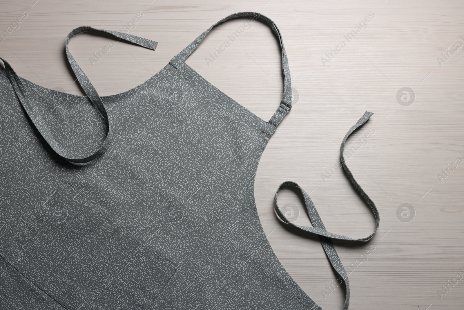 Photo of Stylish apron on white wooden table, top view. Mockup for design