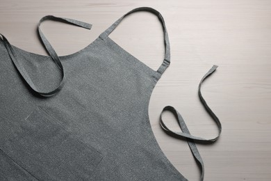 Stylish apron on white wooden table, top view. Mockup for design