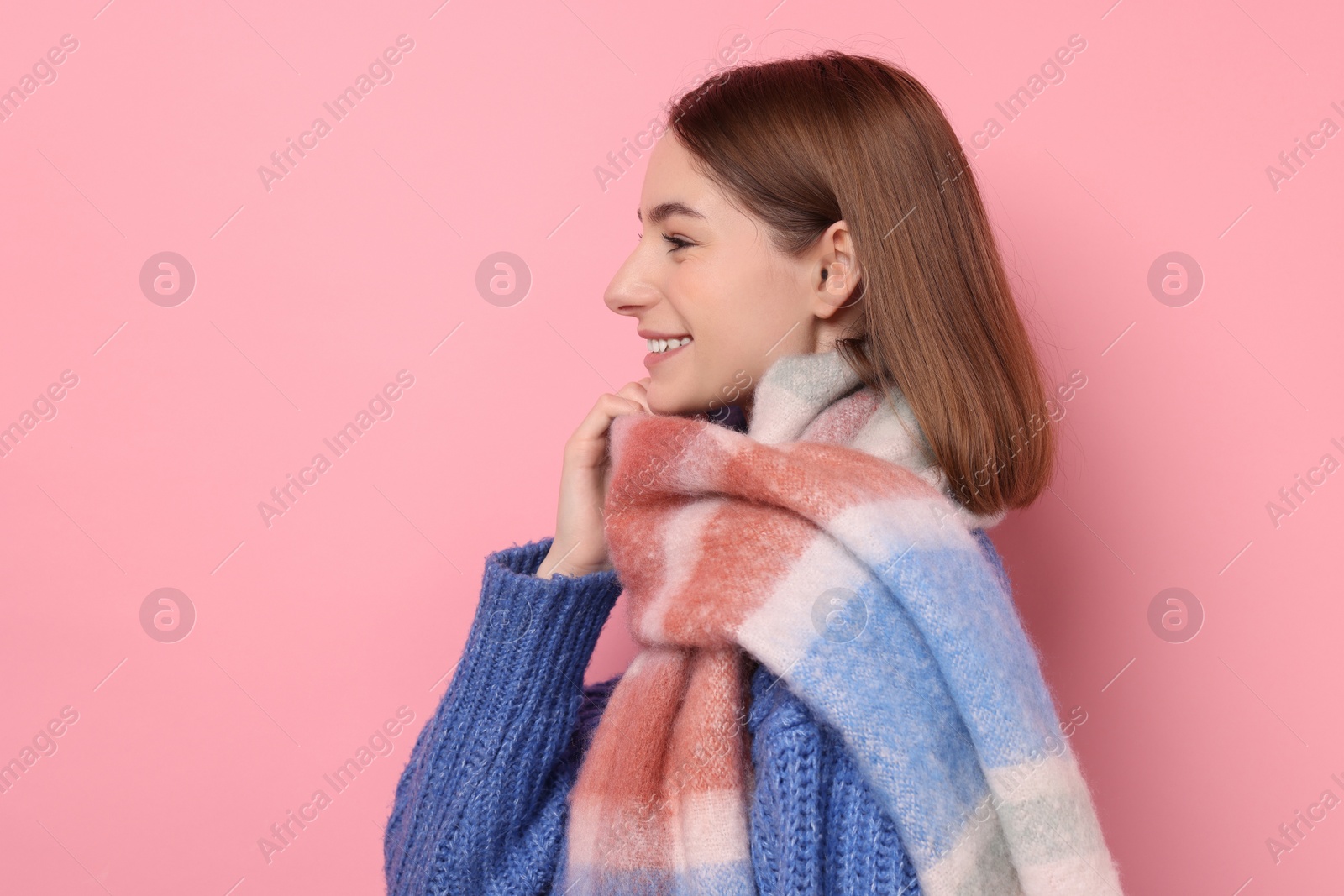 Photo of Beautiful woman in warm scarf on pink background