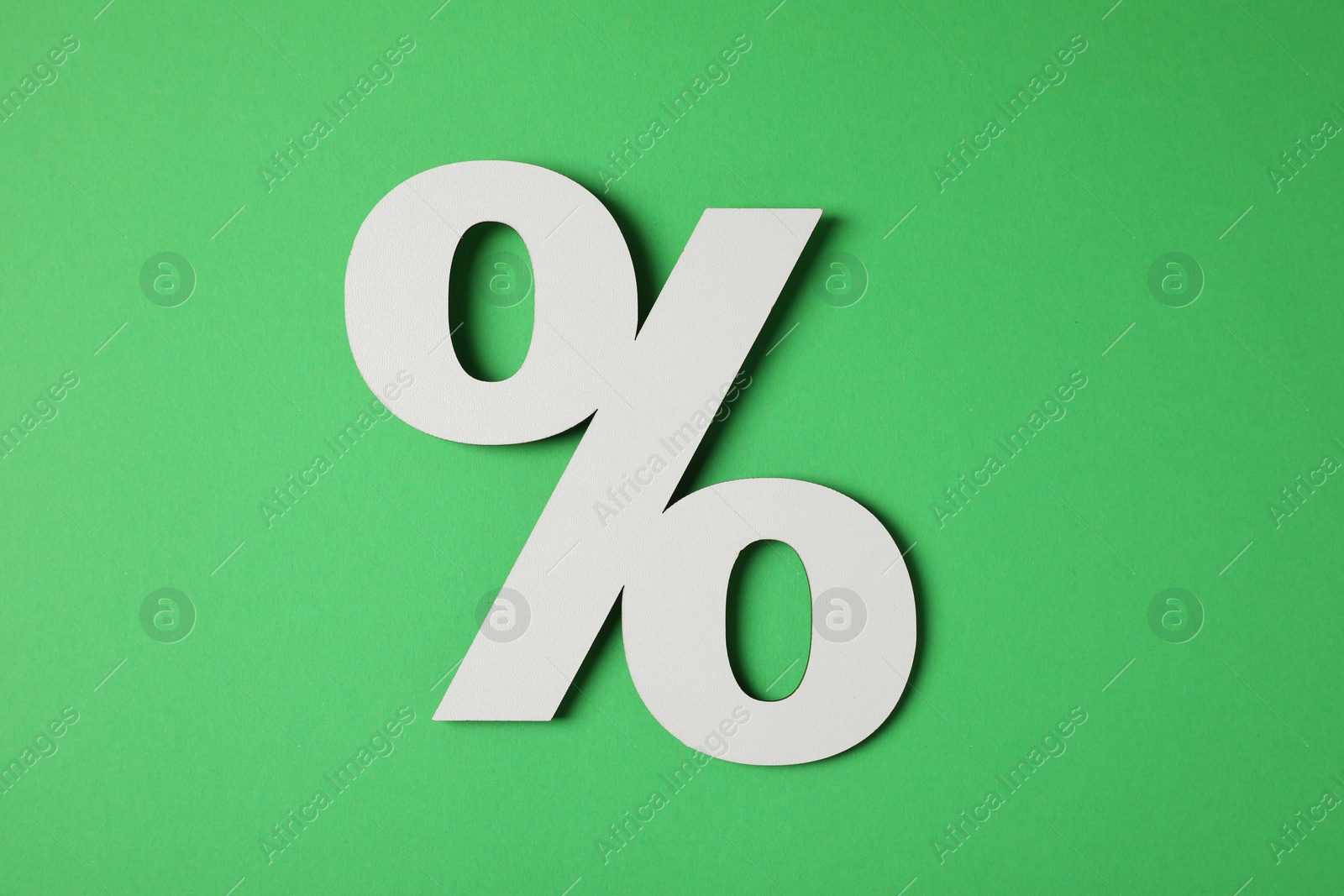 Photo of Wooden percent sign on green background, top view