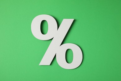 Photo of Wooden percent sign on green background, top view