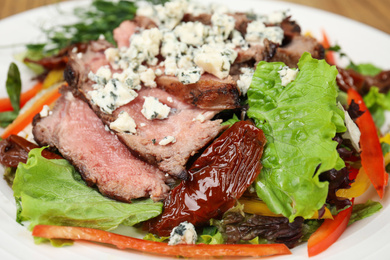 Photo of Delicious salad with roasted meat and vegetables on plate, closeup