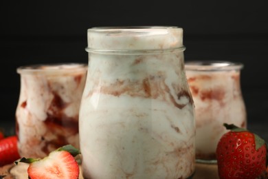 Photo of Tasty yoghurt with jam and strawberries on table, closeup