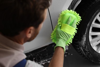 Photo of Worker washing auto with sponge at car wash, closeup