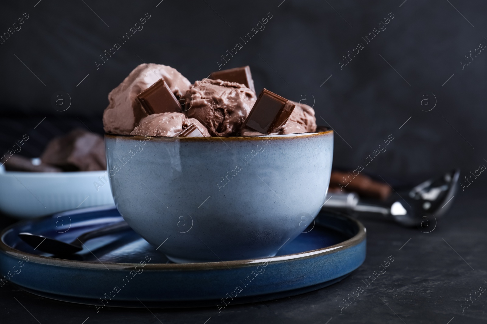 Photo of Yummy chocolate ice cream in bowl on black table