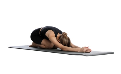 Young woman in sportswear practicing yoga on white background