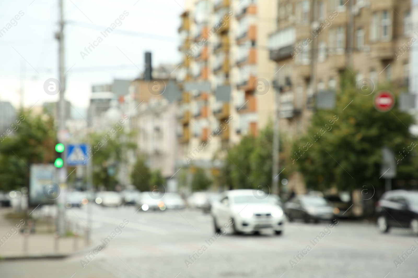 Photo of Blurred view of quiet city with buildings and cars on road