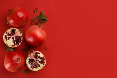Photo of Flat lay composition with ripe pomegranates on red background. Space for text