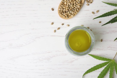 Jar of hemp cream and seeds on white wooden table, flat lay with space for text. Organic cosmetics