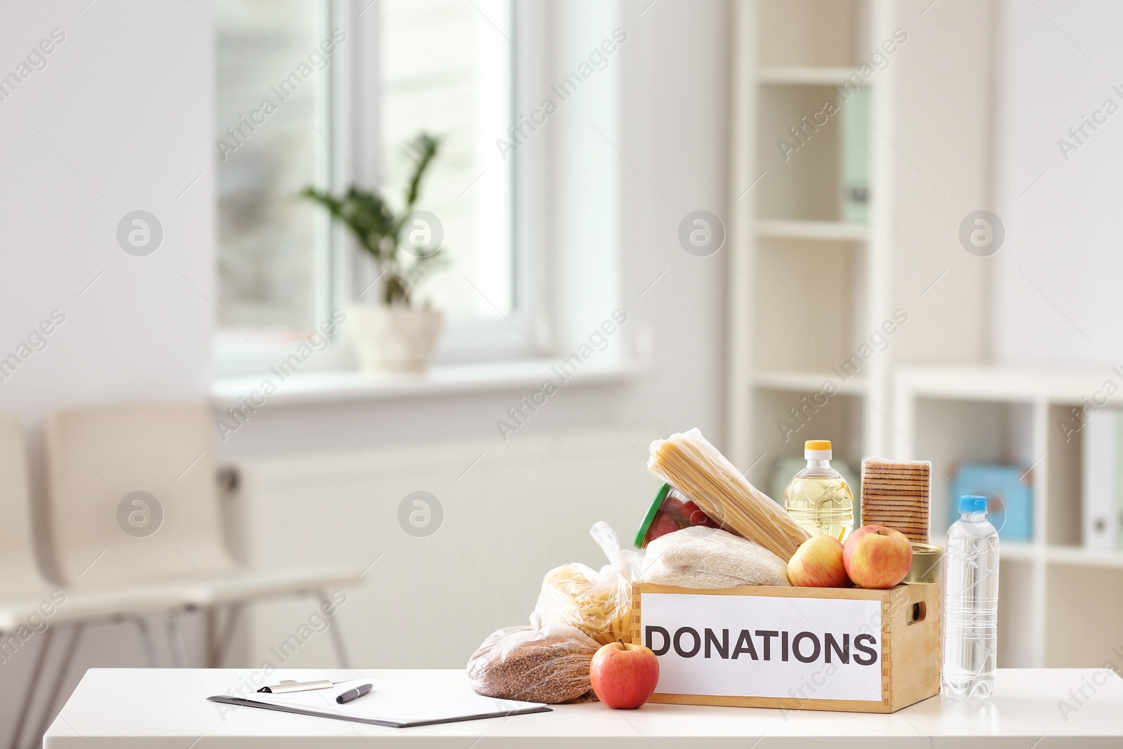 Photo of Donation box with food products on table indoors