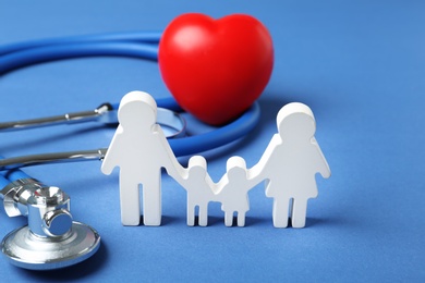 Photo of Family figure with stethoscope and heart on color background. Life insurance concept