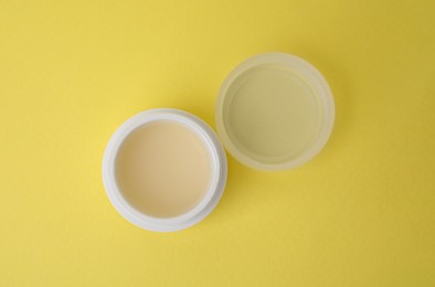 Jar of petroleum jelly on yellow background, top view