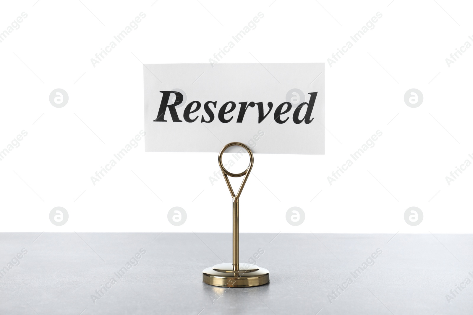 Photo of Elegant sign Reserved on light grey table against white background