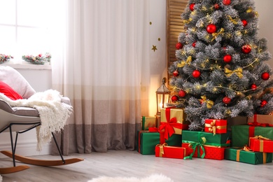 Stylish room interior with beautiful Christmas tree and gift boxes