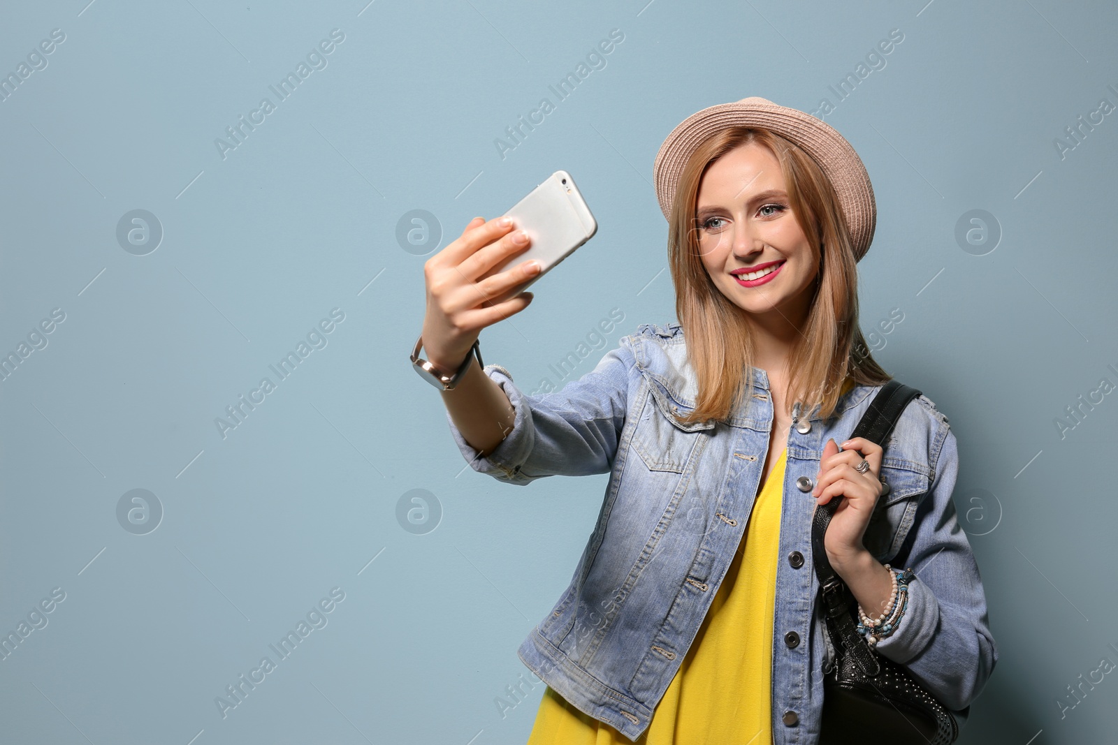 Photo of Attractive young woman taking selfie on color background