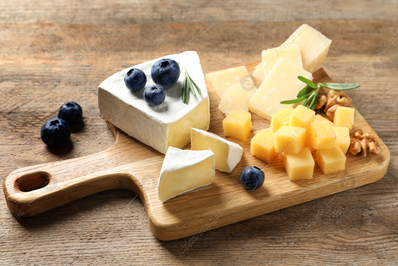 Photo of Different delicious cheeses served on wooden table