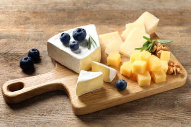 Different delicious cheeses served on wooden table