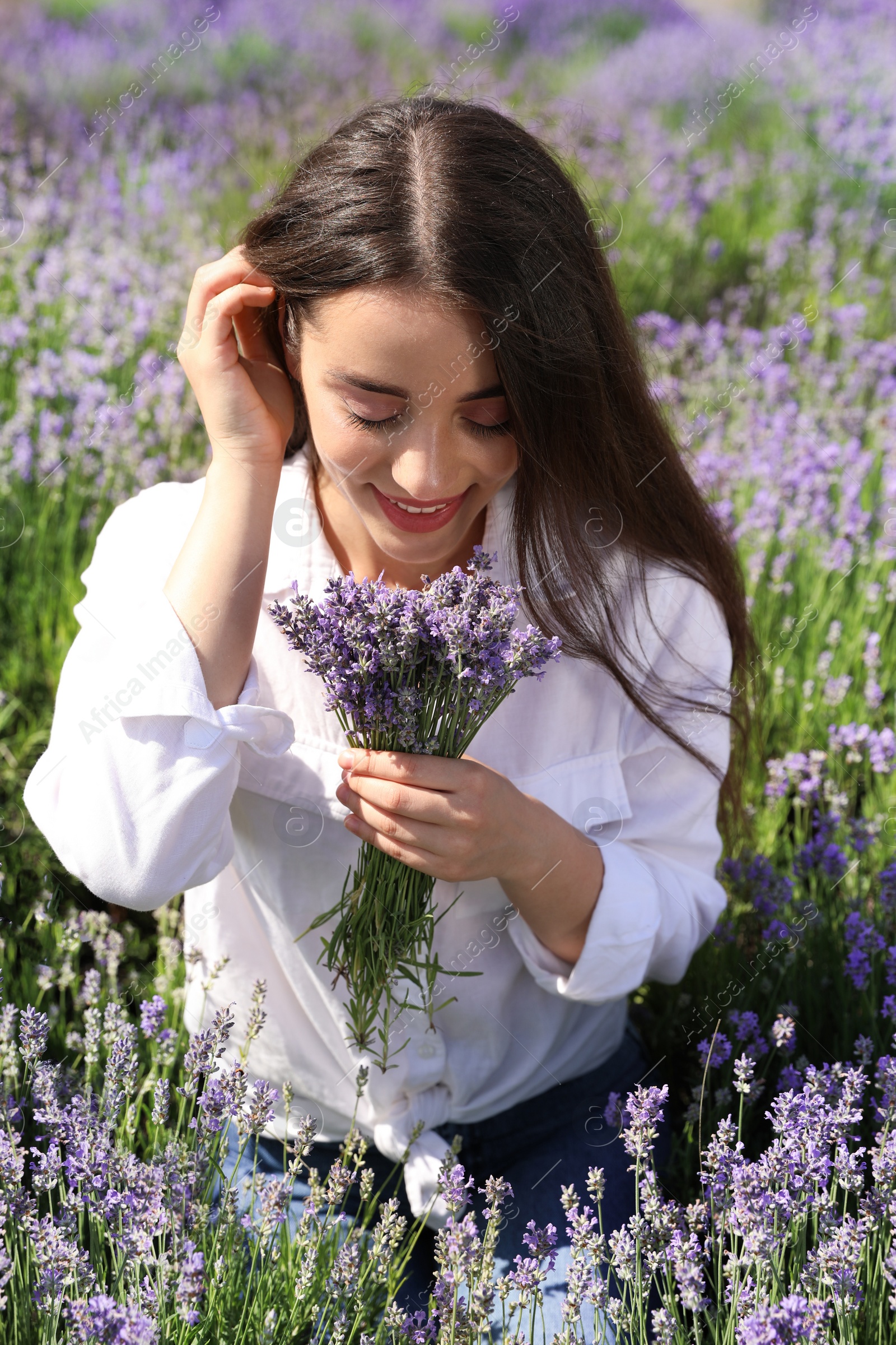 Photo of Young woman with lavender bouquet in field on summer day