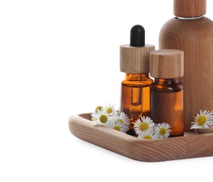 Photo of Bottles of chamomile essential oil and flowers on white background