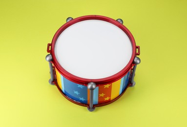 Photo of Colorful drum on light green background. Percussion musical instrument