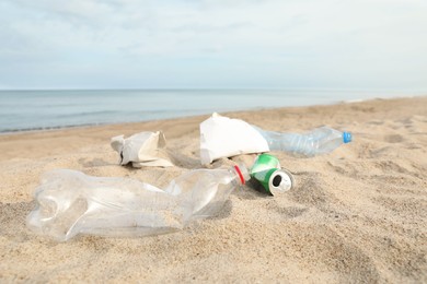 Garbage scattered on beach near sea. Recycling problem