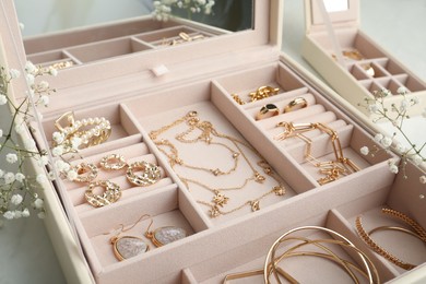 Photo of Jewelry box with different elegant bijouterie and flowers on white table, closeup