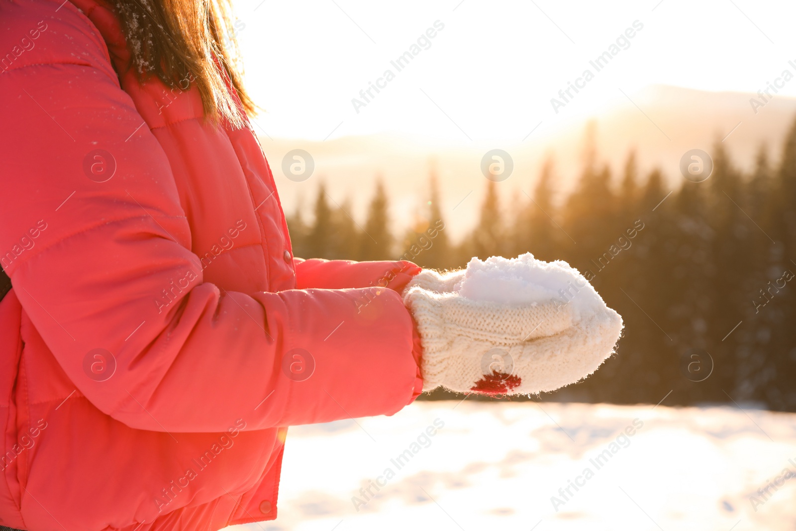 Photo of Woman holding pile of snow outdoors, closeup. Winter vacation