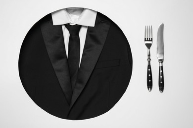 Photo of Creative business lunch layout. Hole with suit as plate and cutlery on white background