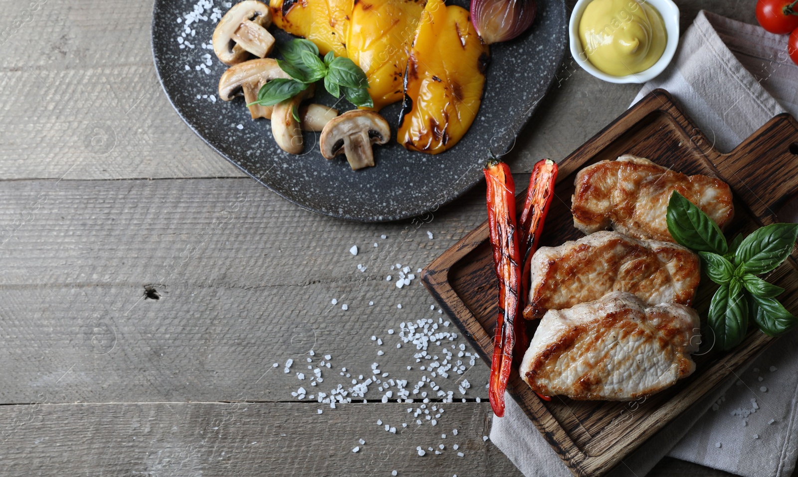 Photo of Delicious grilled meat and vegetables served on wooden table, flat lay. Space for text