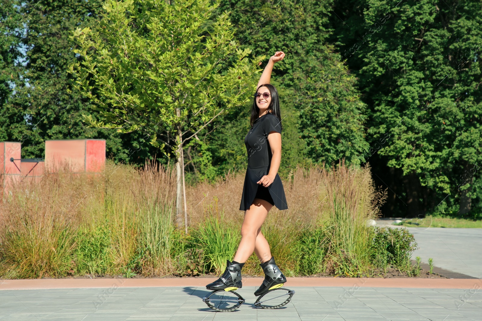 Photo of Woman doing exercises in kangoo jumping boots outdoors