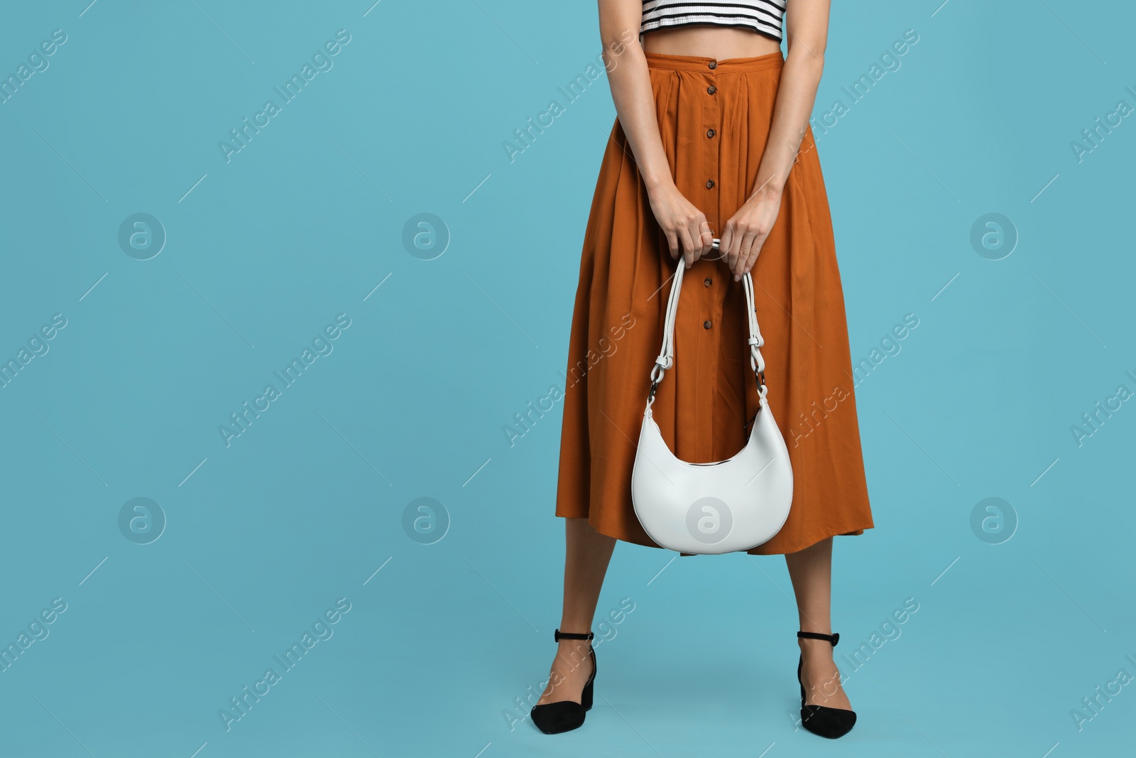 Photo of Stylish woman with trendy baguette bag on turquoise background, closeup. Space for text