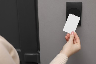 Photo of Woman opening magnetic door lock with key card, closeup. Home security