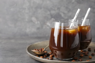 Glasses with cold brew coffee and beans on tray