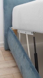 Closeup view of lifting mechanism for opening under bed storage