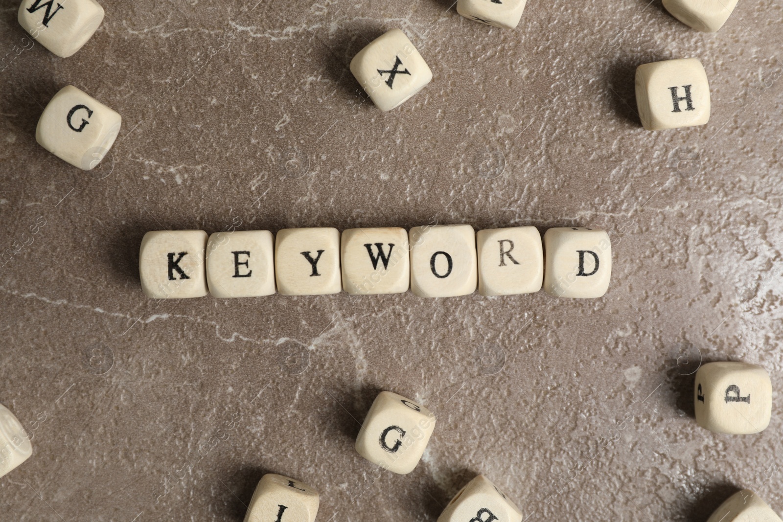 Photo of Beads with word KEYWORD on marble background, flat lay