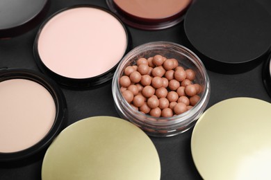 Different face powders on black table, closeup