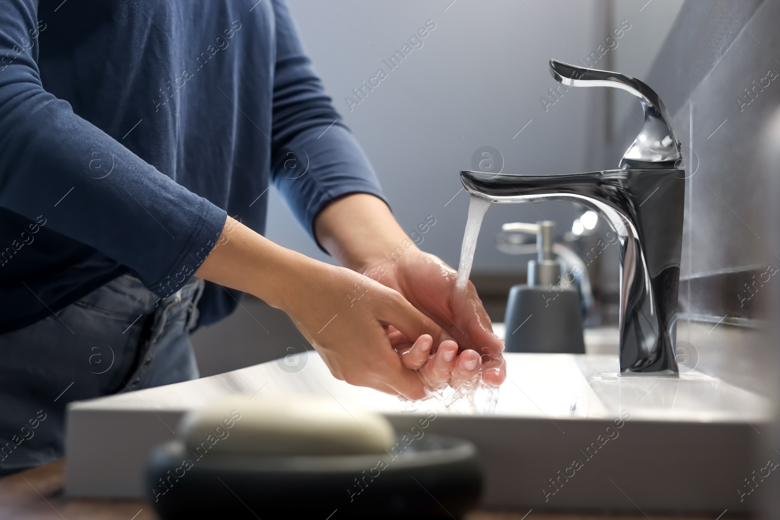 Photo of Woman washing hands in bathroom, closeup view