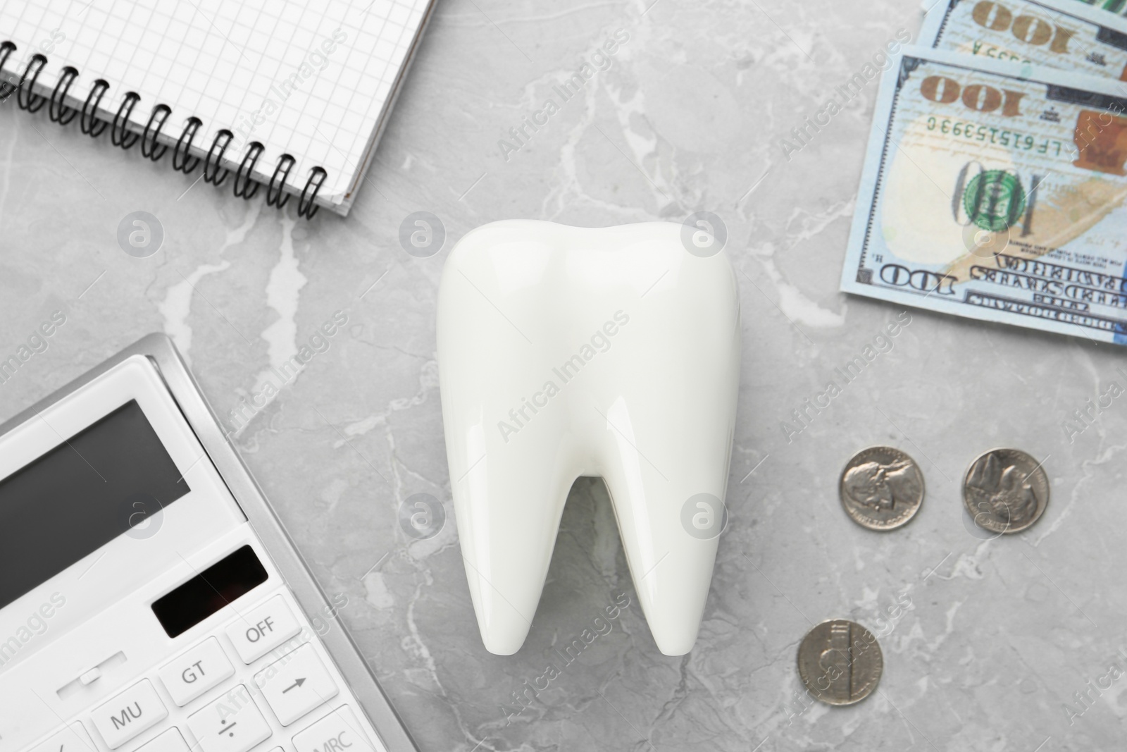 Photo of Flat lay composition with ceramic model of tooth and money on grey table. Expensive treatment