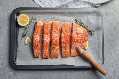 Photo of Baking dish with fresh marinated salmon, top view