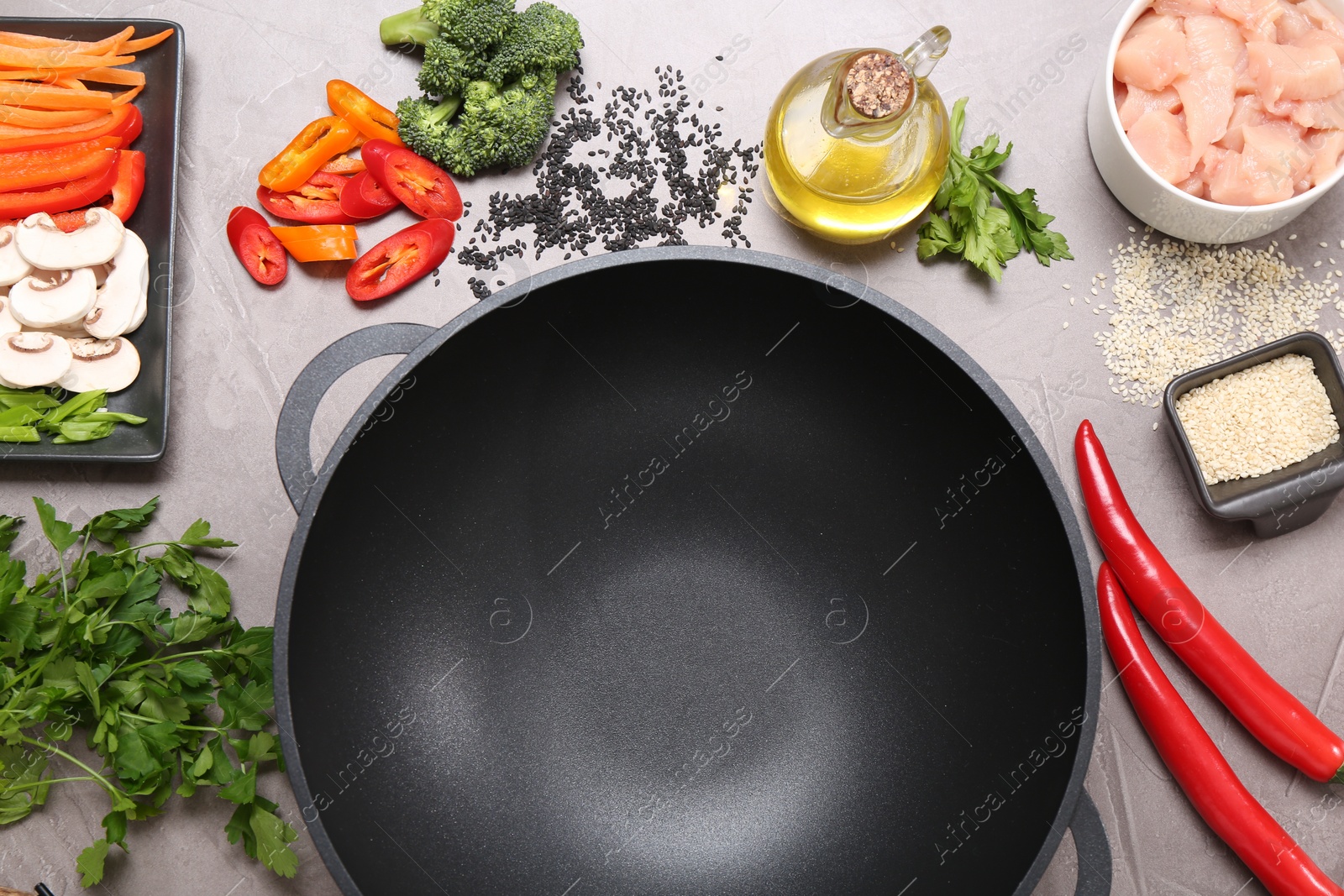 Photo of Wok and different products on grey textured table, flat lay