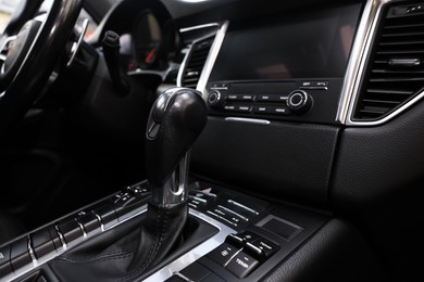 Photo of Gear stick inside of modern black car, closeup