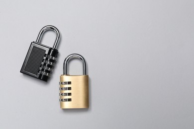 Photo of Steel combination padlocks on grey background, top view. Space for text