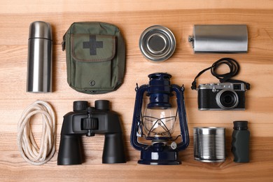Photo of Set of traveler's equipment on wooden table, flat lay