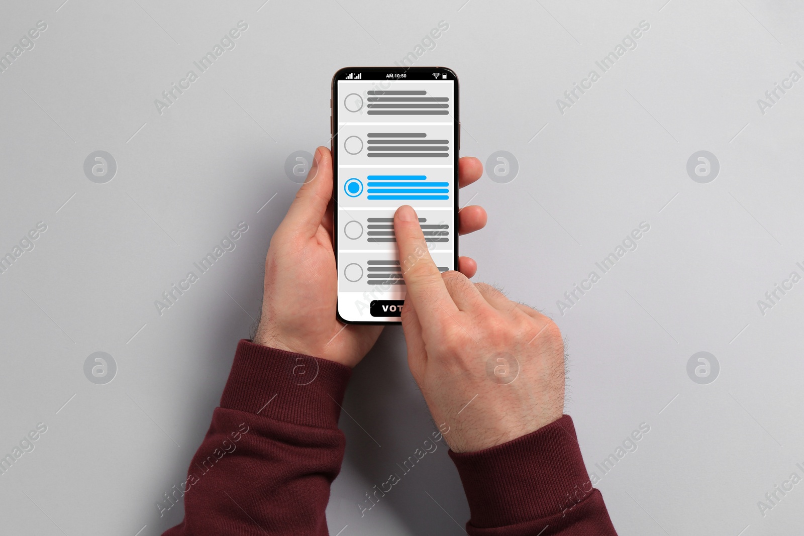 Image of Man voting online via smartphone on light grey background, top view