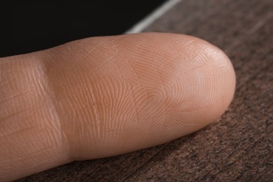Photo of Closeup view of human finger on wooden surface