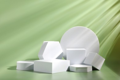 Photo of Product photography props. Podiums of different geometric shapes on light pale green background