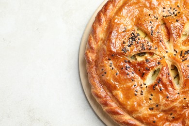 Photo of Tasty homemade pie with filling on light table, top view. Space for text