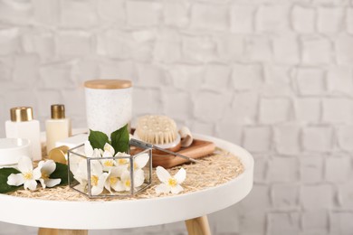 Photo of Composition with beautiful jasmine flowers and skin care products on white table, space for text